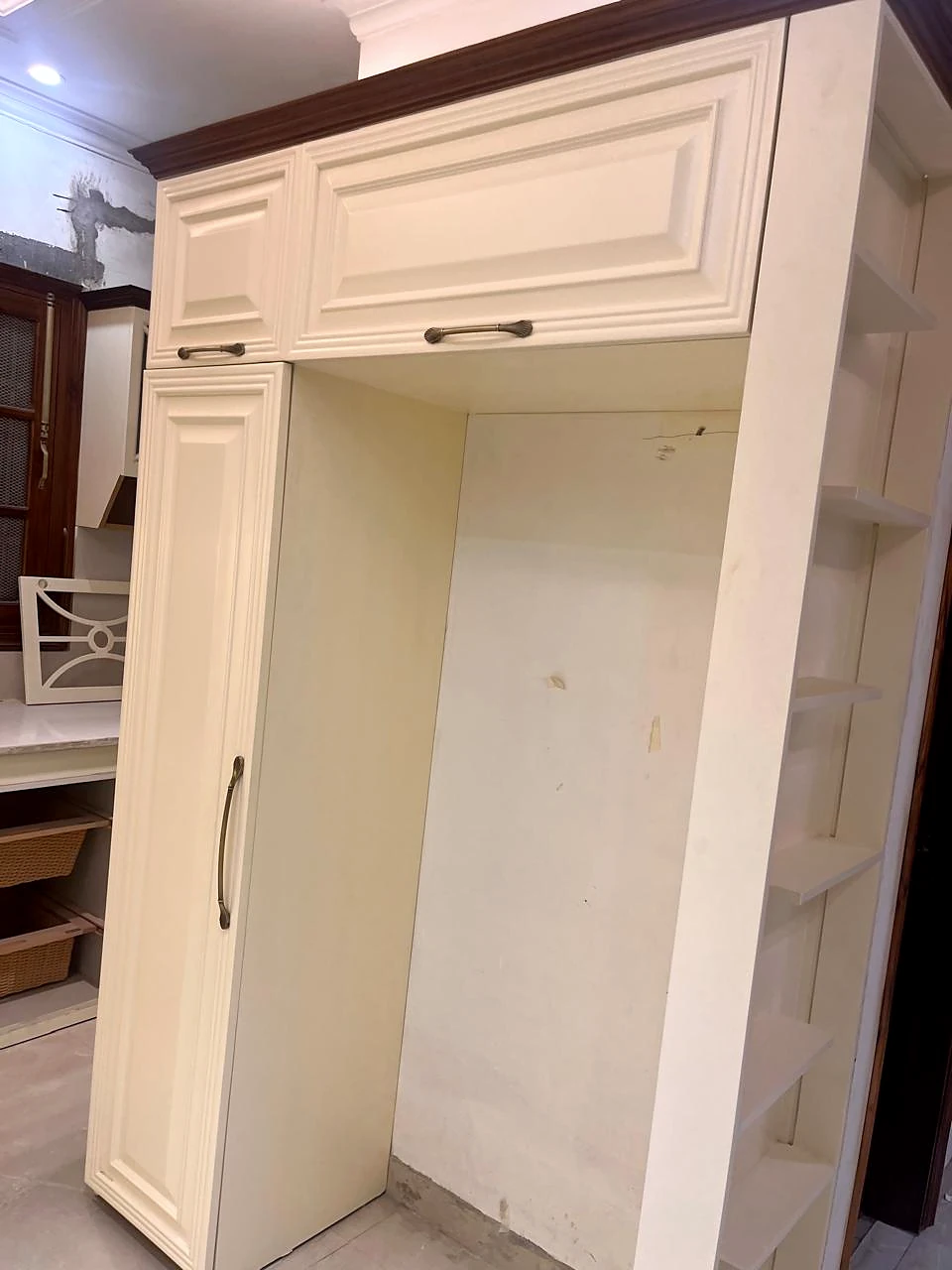 Tall cabinet niche beside the kitchen pantry storage