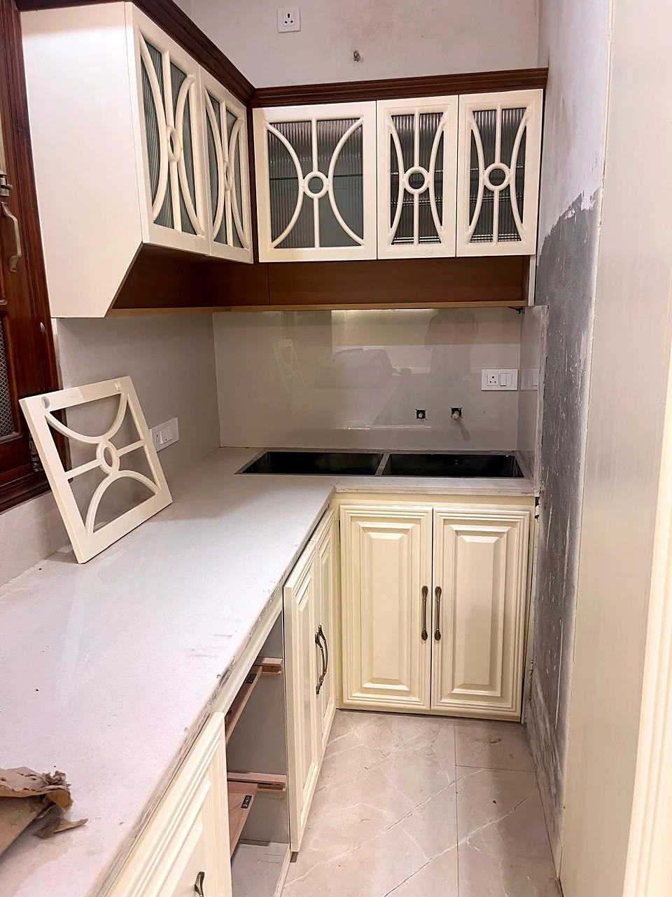 Countertop view beneath decorative metal-front kitchen cupboards