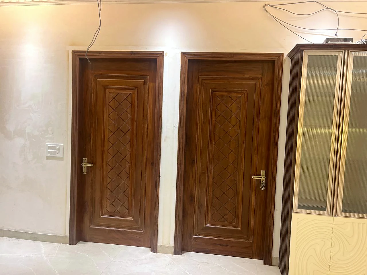 Pair of decorative timber doors in a warm-lit interior passage