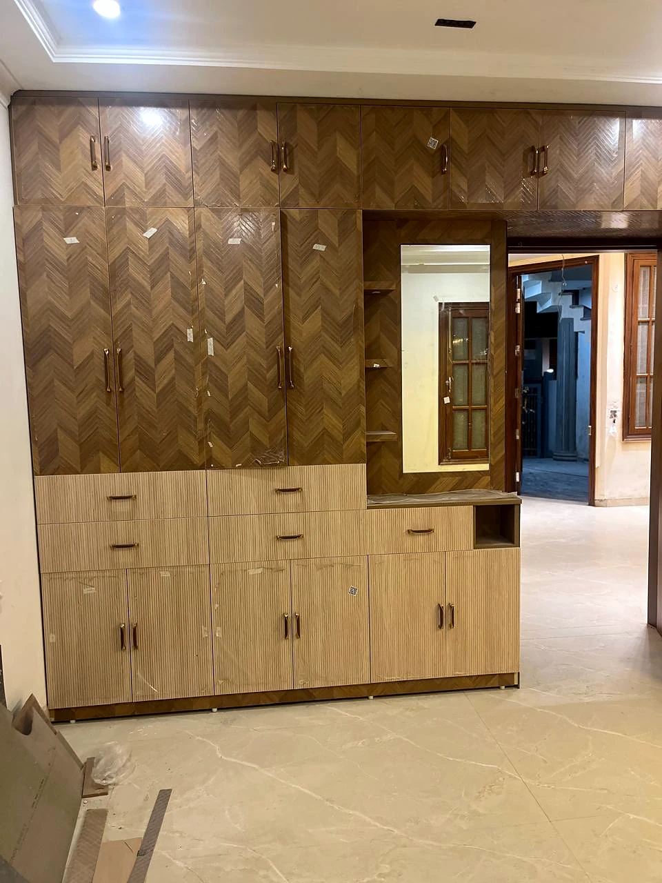 Walnut-toned media wall above a run of built-in base cabinets