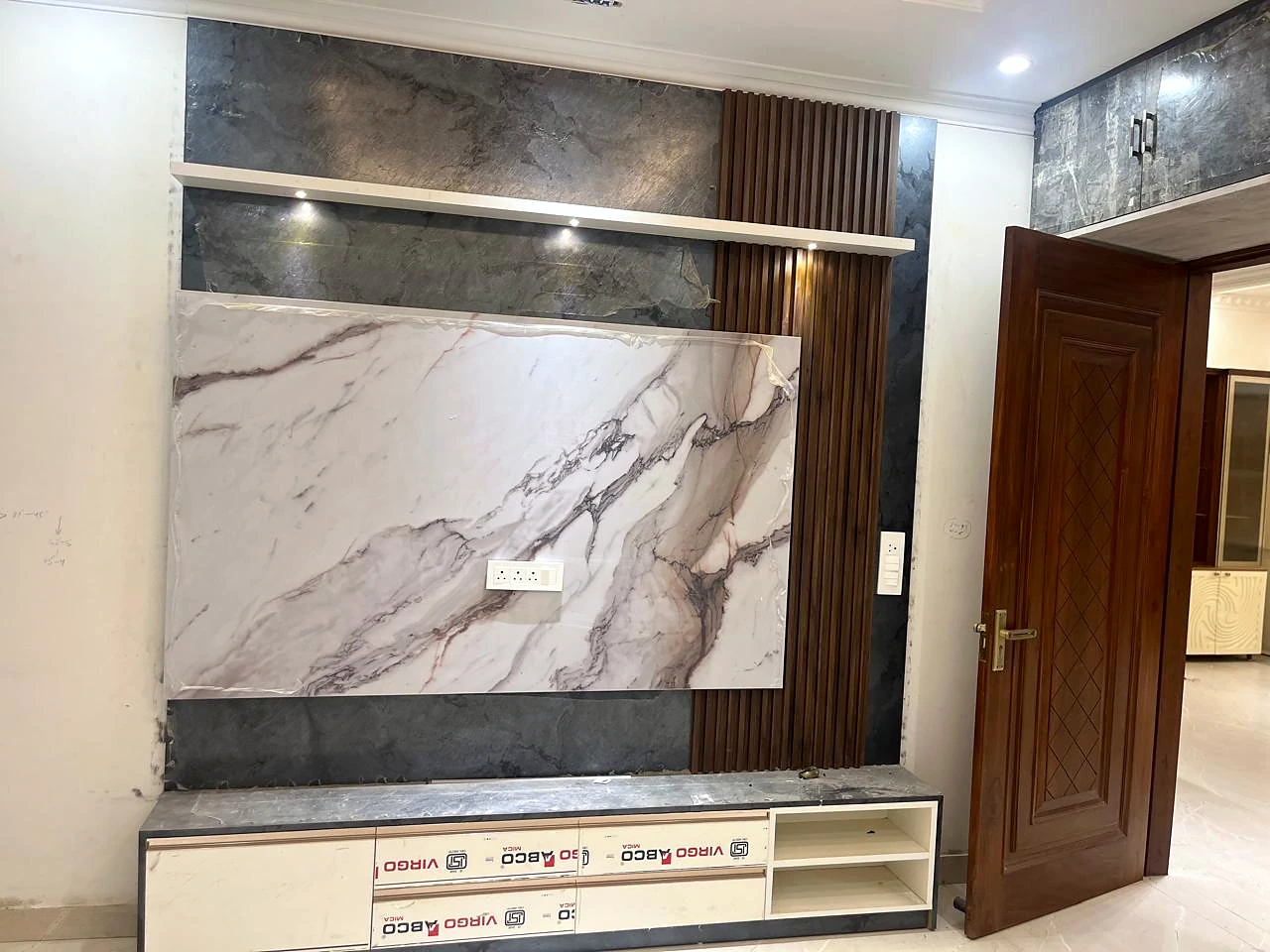 Wide living-room media wall with a stone-look panel and timber slats