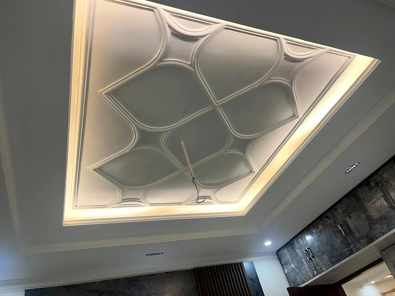 Layered false ceiling with geometric inset and cove lighting