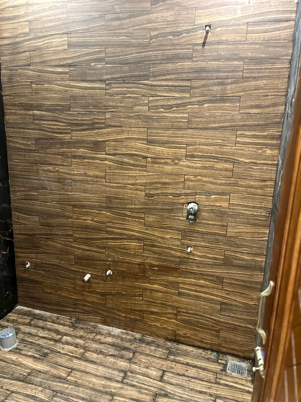 Close view of the wood-grain feature wall and adjoining stone-look finish