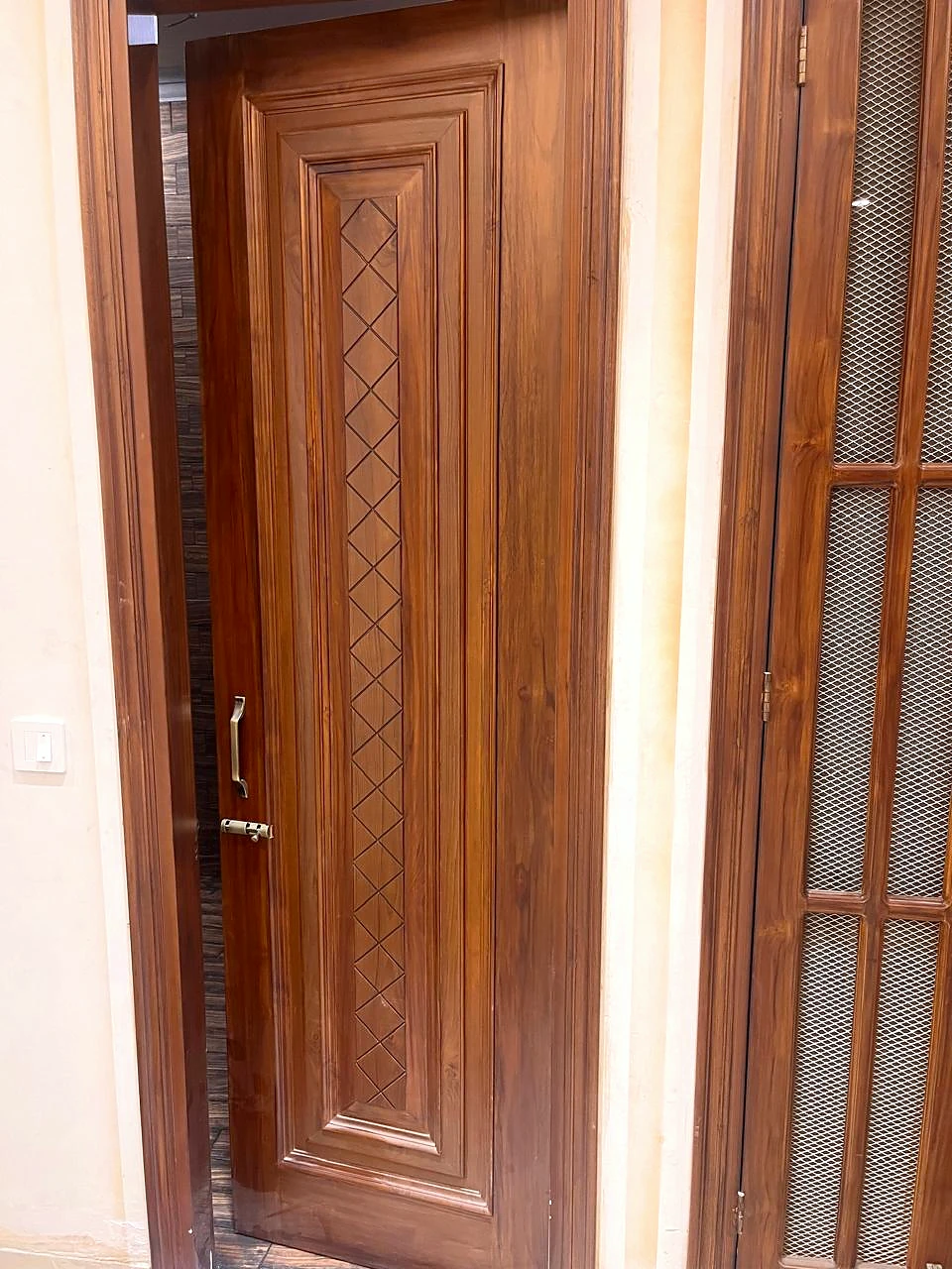 Carved timber door framed by a narrow glazed side panel