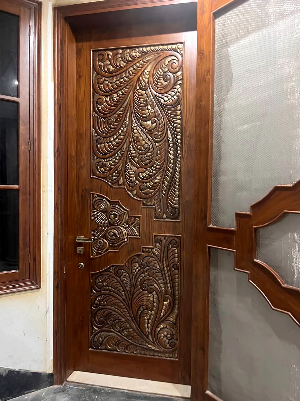 Ornately carved entrance door and surrounding wall detail