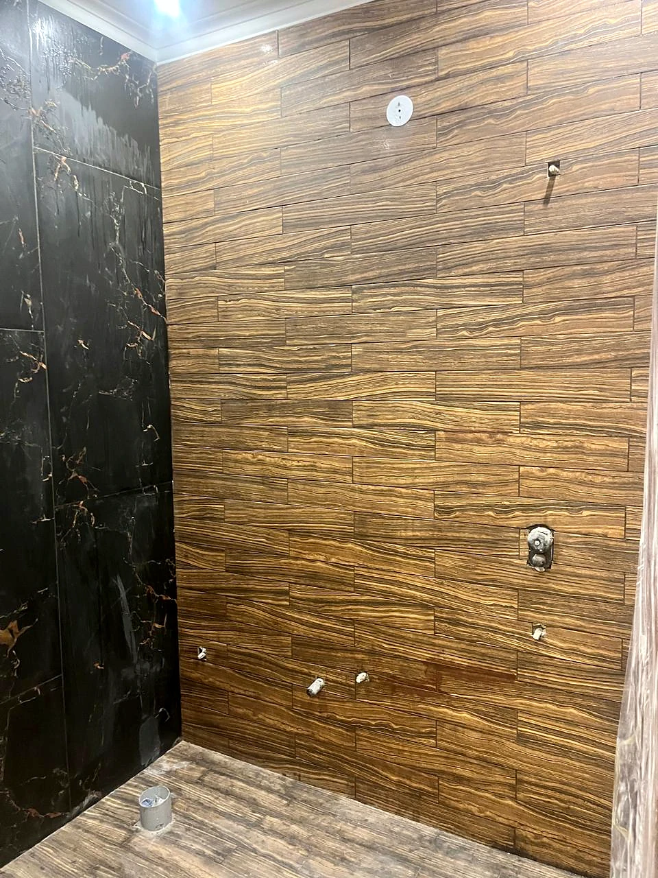 Close view of the wood-grain and dark stone-look wall finishes