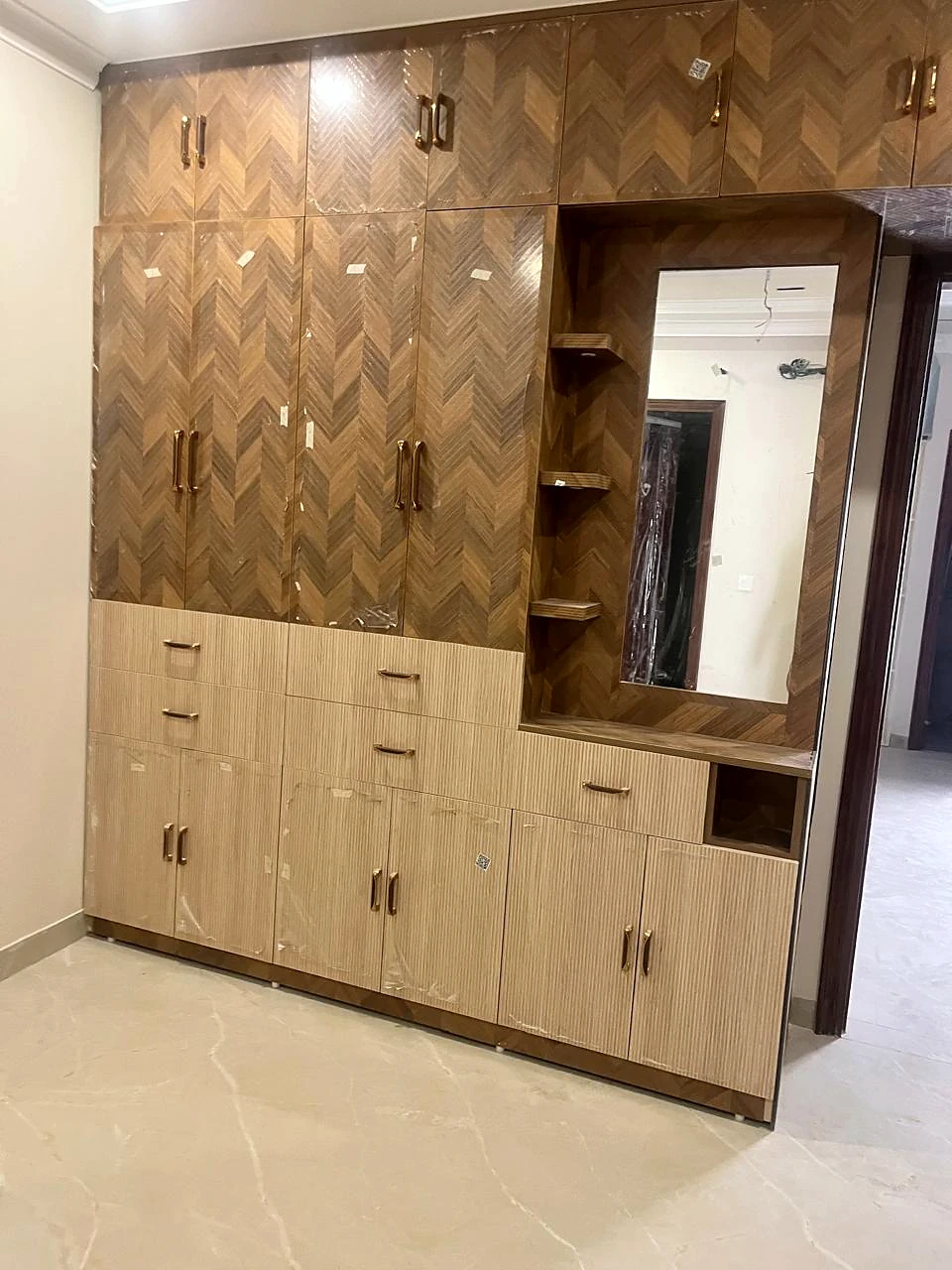 Walnut geometric feature wall with lower storage and an inset mirror
