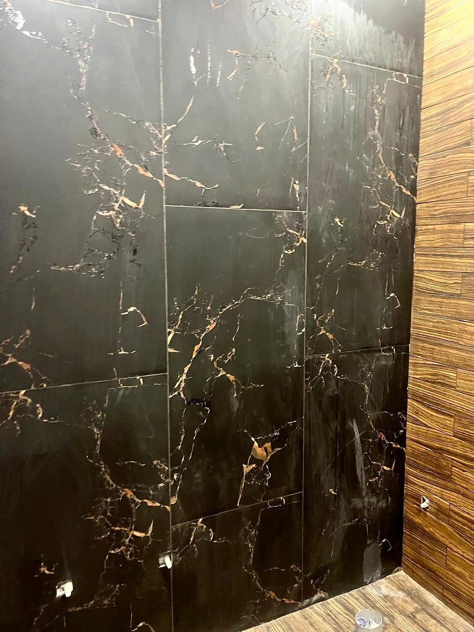 Dark stone-look wall with a contrasting wood-grain panel