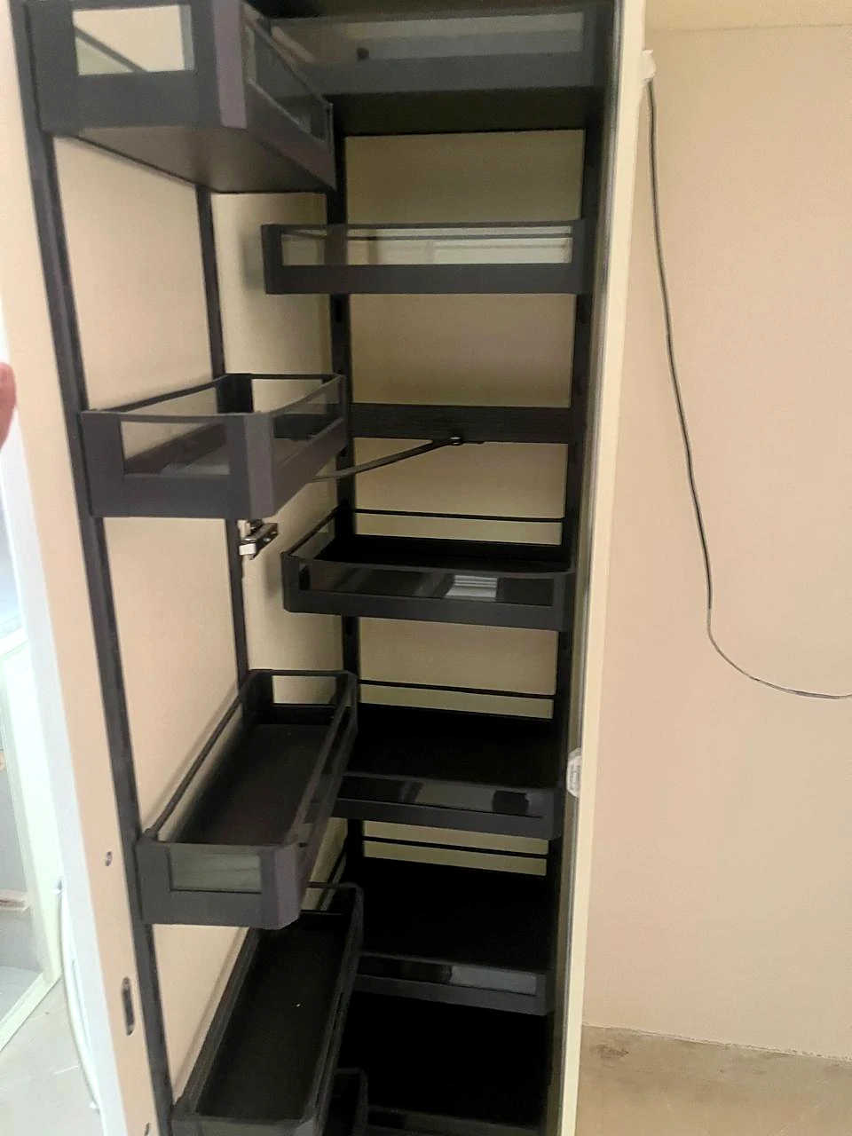 Pull-out pantry drawers inside a narrow storage cabinet