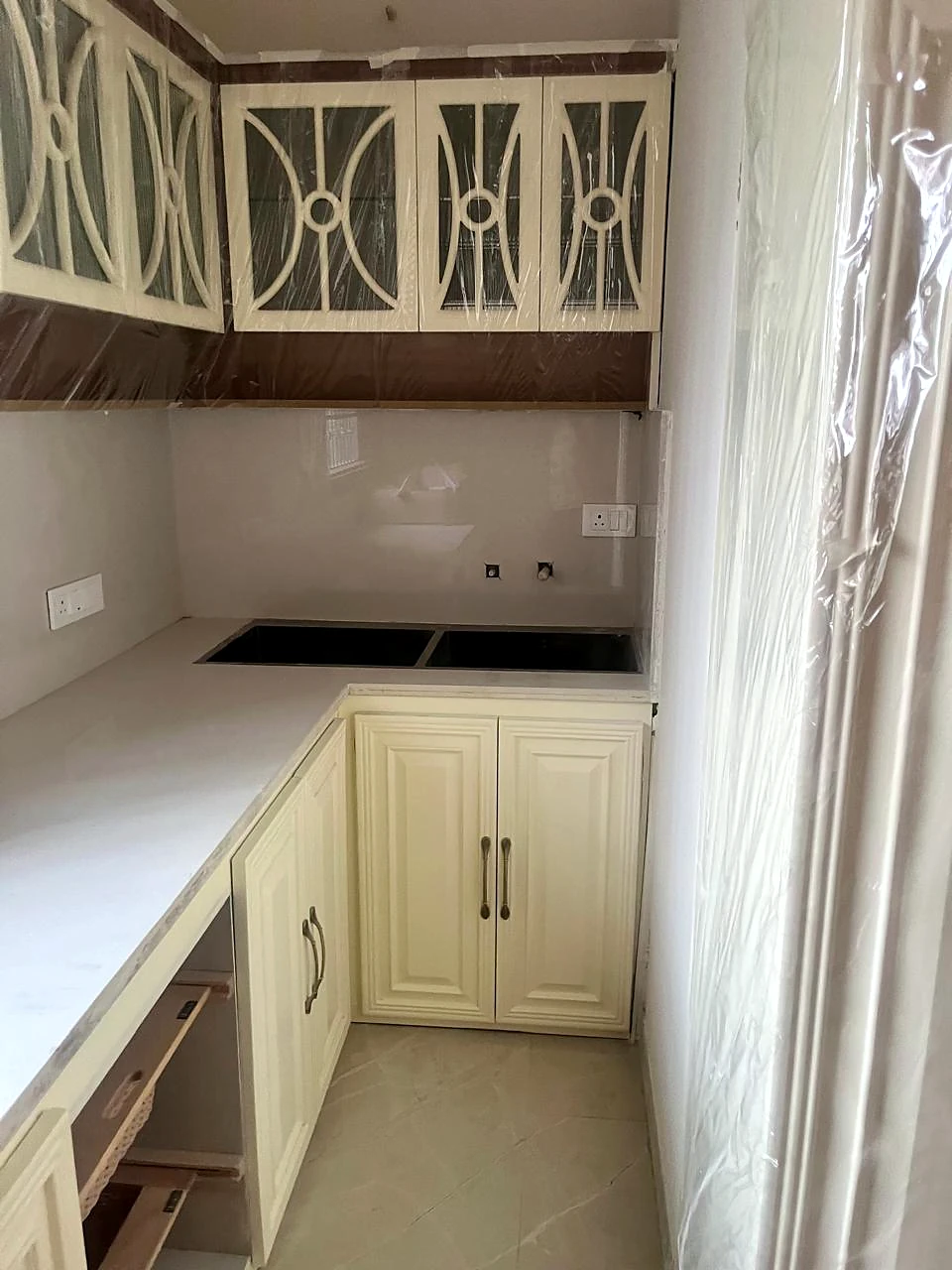 End view of kitchen cabinetry with decorative metal-front upper doors