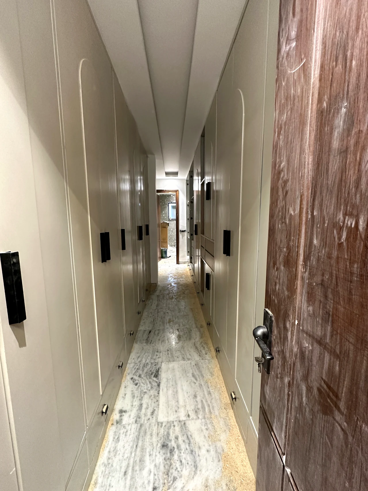 Second hallway angle with the entry door and floor finish in view