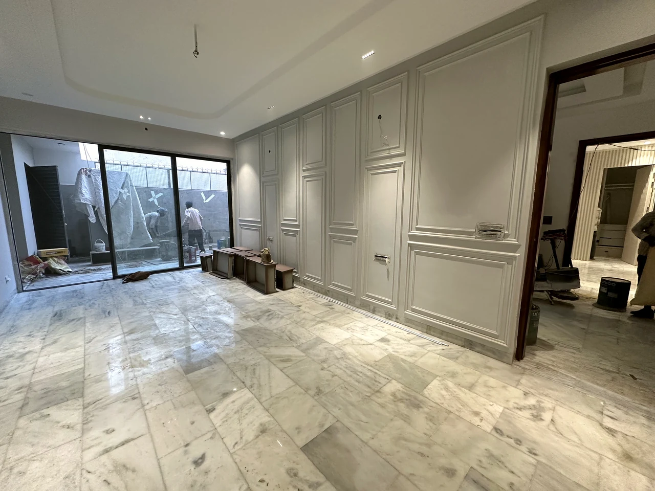 Wide living room view with wall panelling and full-height glazing