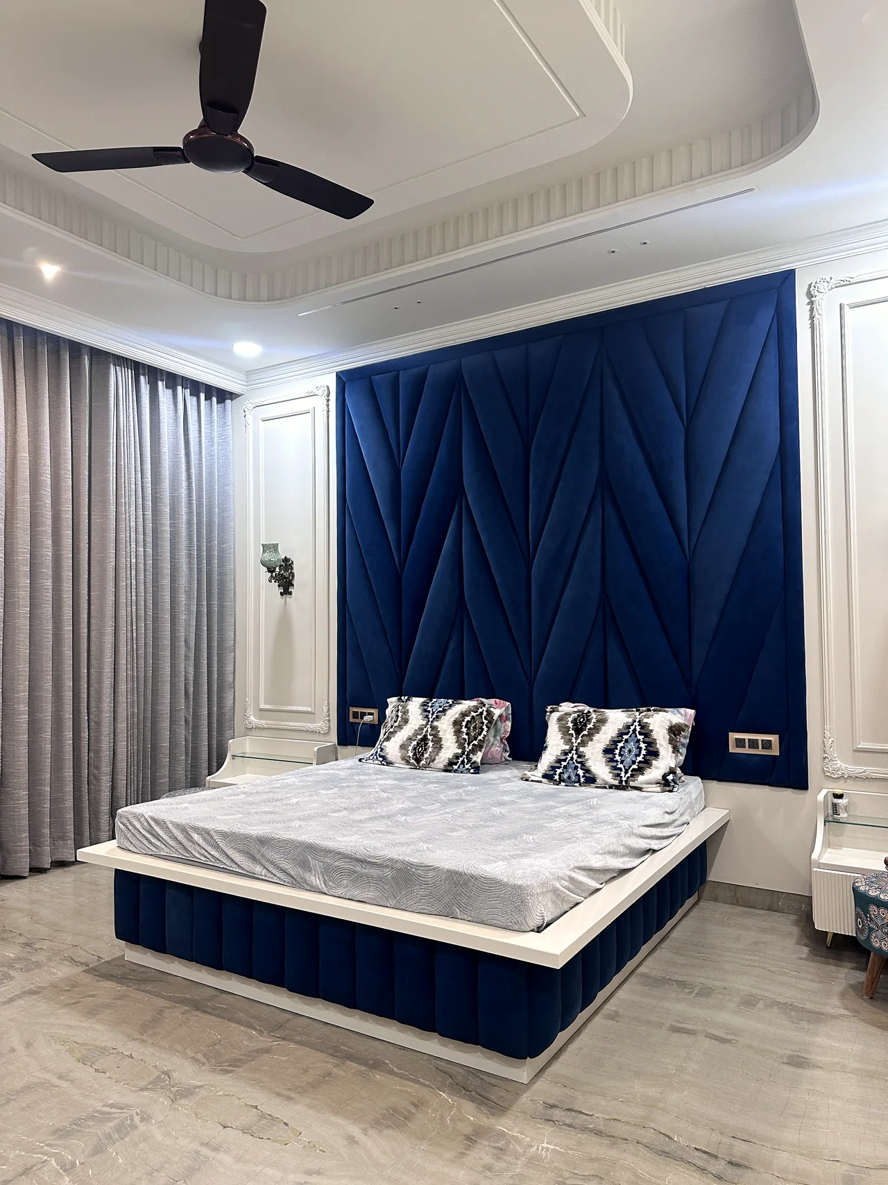 Blue-accented bedroom with a tailored upholstered bed wall