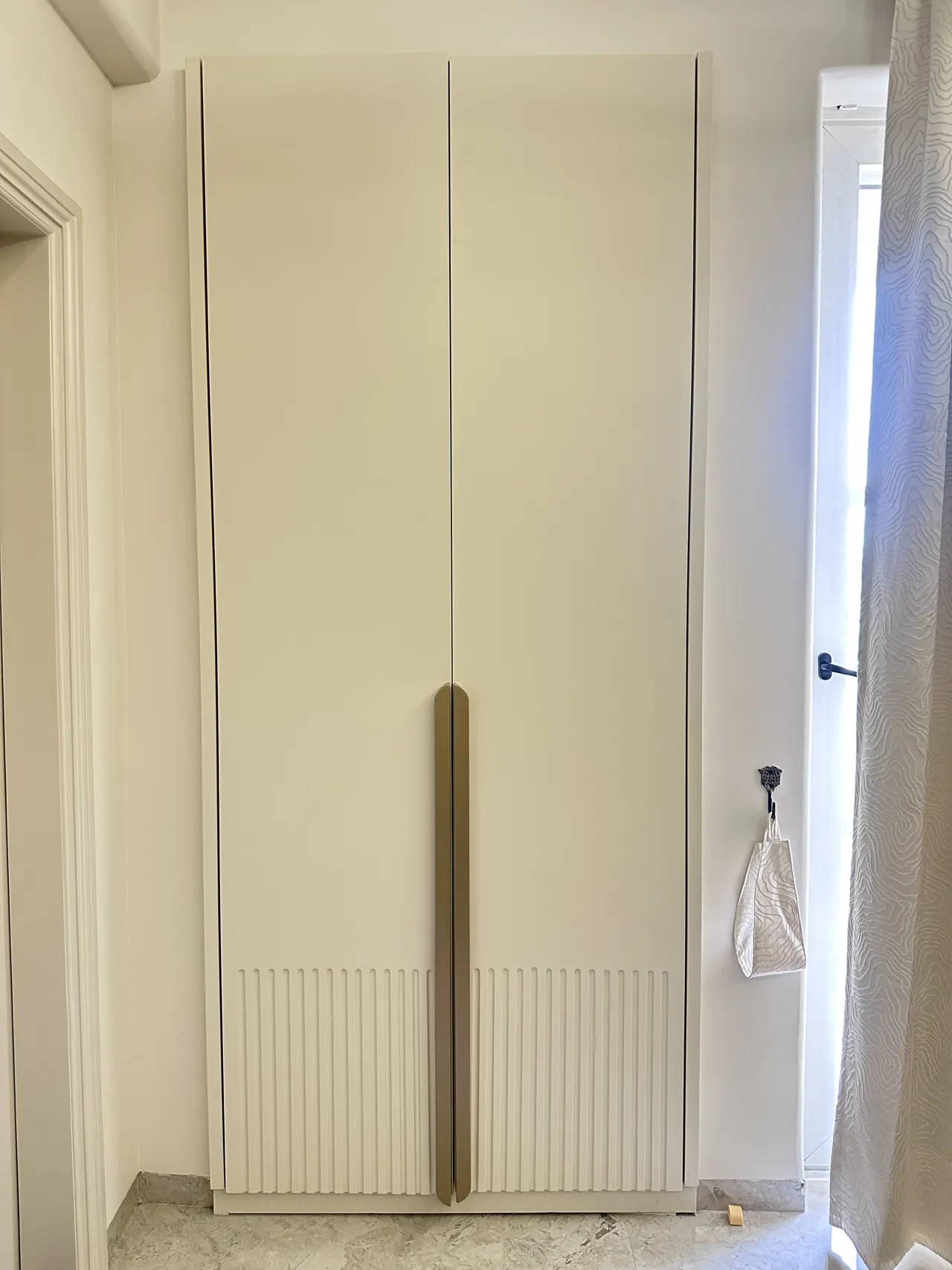 Full-height wardrobe framed by the room doorway and curtain