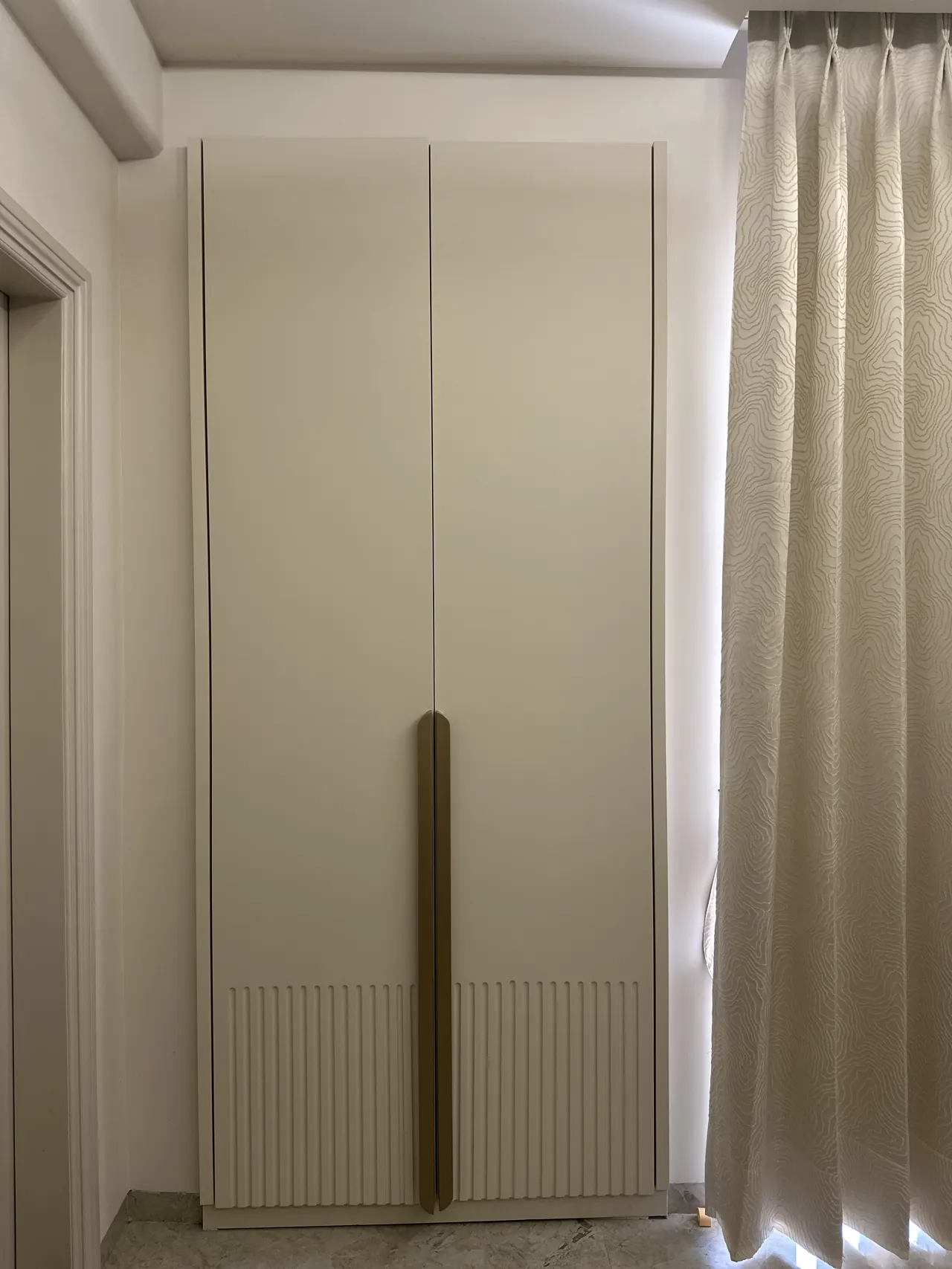 Wardrobe and patterned drapery in the bedroom